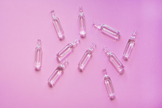 Vaccine For COVID-19. Ampoules With Medicine For Coronavirus On A Pink Background. Development And Use Of A Cure For A New Virus