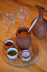 clay pot and spoon, stew (meat in the pot)