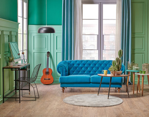 Green living room wall and white window, blue sofa, vae of big plant on the brown parquet with turquoise curtain style.