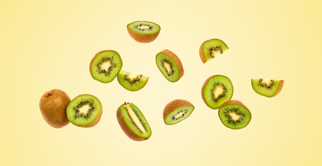 Fresh kiwi fruit flying in air on yellow. Fruity green color diet food. Summer whole, cut kiwi background. Colorful levitation concept. Falling fly kiwi, fruity creative vivid design