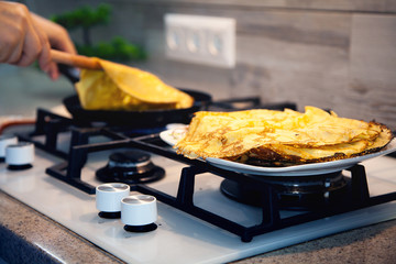 Cooking breakfast in the kitchen. We fry pancakes for Shrovetide