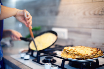 Cooking breakfast in the kitchen. We fry pancakes for Shrovetide