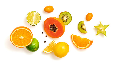 Creative fresh fruits layout. Papaya, apple, orange, kiwi, melon isolated on white background. Fruity diet summer concept. Tropical mix background. Colorful summertime fruit flat lay.
