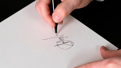 Businessman signing contract agreement, male hand with pen writing signature.