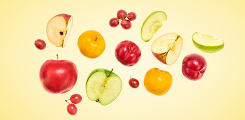 Flying Fruits healthy food summer color background. Apple, plum, grape. Colorful levitation, falling fly fruit creative vitamin concept. Colorful fruity summertime vivid design