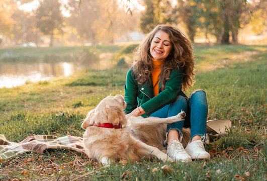 Happy woman rest with her dog golden retriever. Female athlete enjoying outdoor with her pet. woman is training outside during season time