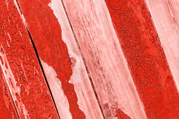 Vintage background red and scarlet color from wooden batten. Old wood slats with paint cracks.