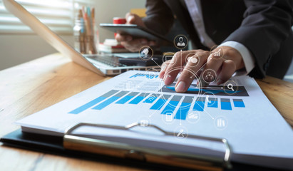 Fototapeta premium Business documents on the desk with a notebook and business graph graph with office icons in the morning. concept.