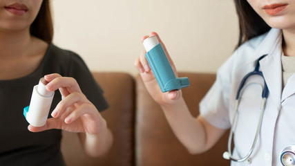Female doctor/pharmacist teaching inhaler device technique to COPD or asthma patients. She explains how to use the medicine inhaler, indications and side effects. Health care and medical. Close up. - obrazy, fototapety, plakaty