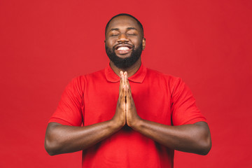 Praying african american man hoping for better. Asking God for good luck, success, forgiveness. Power of religion, belief, worship. Holding hands in prayer, eyes closed.