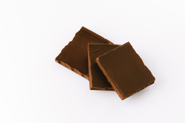 Macro photo of Chocolate bar. Broken pieces over white background