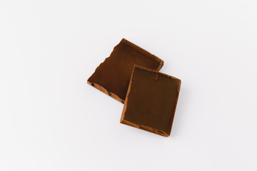 Macro photo of Chocolate bar. Broken pieces over white background