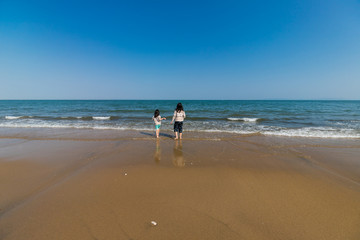 海岸で海遊ぶをしている子供姉妹