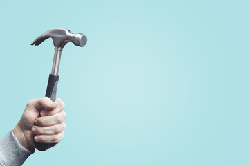 Hammer in hand isolated. Man holding a vintage hammer, tool in the hand.