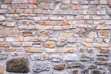 Eine sehr alte verwitterte Stein Ziegelmauer als Hintergrund