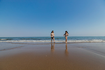 海岸で海遊ぶをしている子供姉妹