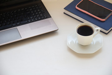 office table desk. Workspace with laptop, diary, mobile and smartphone and other supplies with cup of coffe on white background. Flat lay, top view