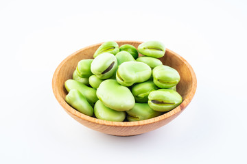 Fresh broad bean pods and broad beans on white background