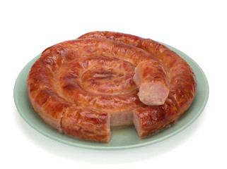 Grilled homemade sausage ring in a plate on white background