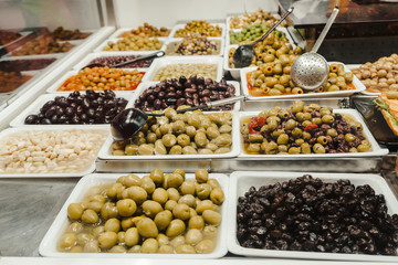 Assortment of olives, pickles and salads on market stand