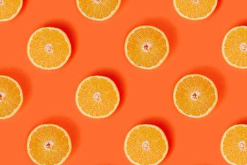 Orange slices pattern on bright orange background. Minimal flat lay concept.
