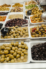 Assortment of olives, pickles and salads on market stand