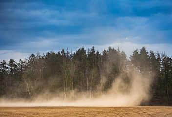 Fototapeta na wymiar Dust storm in dry fields, dry weather infuenced by climate change