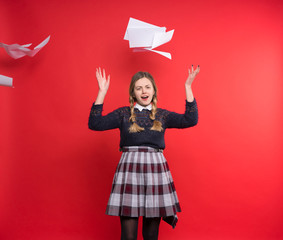 Young schoolgirl with pigtails in a plaid skirt has scattered their notebooks, the concept of...
