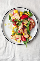 Salad with grilled peaches, corn,  tomatoes and basil.