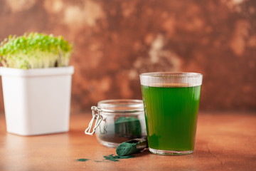 Glass of spirulina drink powder on table. Food and drink, dieting and nutrition concept.
