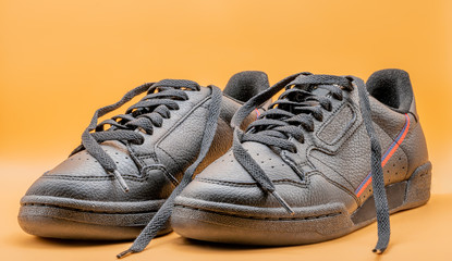 Black sneakers To wear for travelling and  Do not tie sneakers orange background or isolated