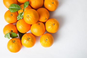 Heap of citrus fruits, ripe fresh oranges with leaves isolated on white background. Top view, copy space. Natural vitamin or organic food concept