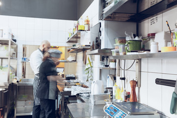 Behind the scenes of brands. The chef cooking in a professional kitchen of a restaurant meal for...