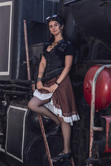 Fototapeta na wymiar Beautiful girl in steampunk clothes on the background of the train