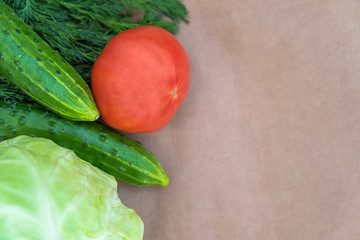 Eco-vegetables on a paper background close-up with a copy space. Tomatoes, cucumbers, dill top view. Soft focus.