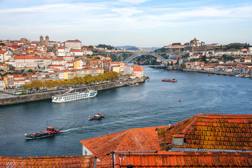 Fototapeta na wymiar Porto, Portugal old town ribeira aerial promenade view with colorful houses, traditional facades, old multi-colored houses with red roof tiles, Douro river and boats. Aerial cityscape image of Porto