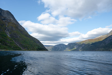 Fjords near Eidfjord with water and high mountains in southern Norway during autumn on a sunny day
