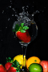 Strawberry splashing into glass of water