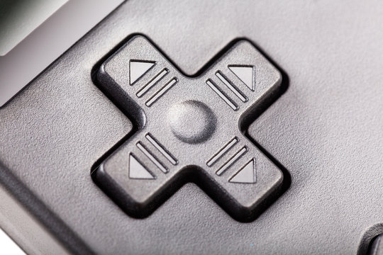 Simple black four directional d-pad. Traditional game controller buttons macro detail, closeup. Plus d pad with arrows, handheld pocket game console digital controls, gaming symbol, abstract concept