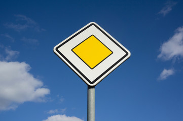 Main road - traffic sign on the road and roadway in the Czech Republic / Czechia. Clear blue sky as copy space