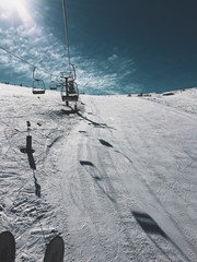 Fototapeta na wymiar mountain top with snow, sky, clouds, ski-run and ski lift 