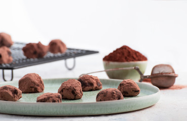 homemade chocolate truffles in a green plate and cocoa powder.