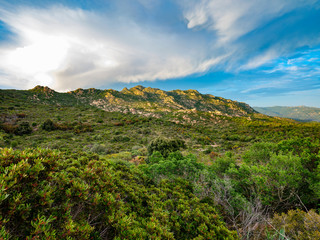 Obraz premium Amazing mountain landscape with colorful vivid sunset on the cloudy sky, natural outdoor travel background. Unspoiled nature of Is Cannoneris natural park, Sardinia, Italy