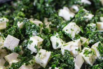 Spinach and feta cheese salad close up. Green healthy lunch. Vegetarian food. Homemade cuisine. Organic meal. Delicious dinner. Plate of green spinach and feta cheese.