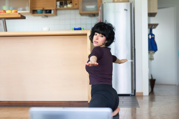 Fototapeta na wymiar Junge sportliche Frau macht Fitness mit online Fitness zuhause