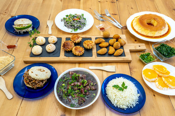 Still life of Brazilian food dishes on pine wood background