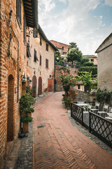 Fototapeta na wymiar Alley in the ancient Tuscan village of Certaldo where the famous writer Giovanni Boccaccio was born and died on a summer morning