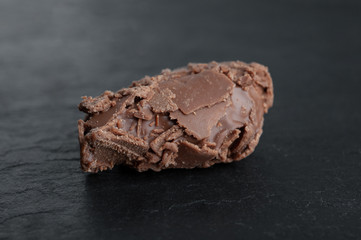  one chocolate truffle on a black stone board