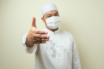 Portrait of young Asian muslim man wearing mask.