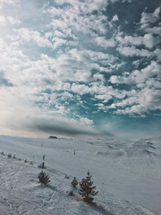 mountain top with snow, sky, clouds, ski-run and ski lift
